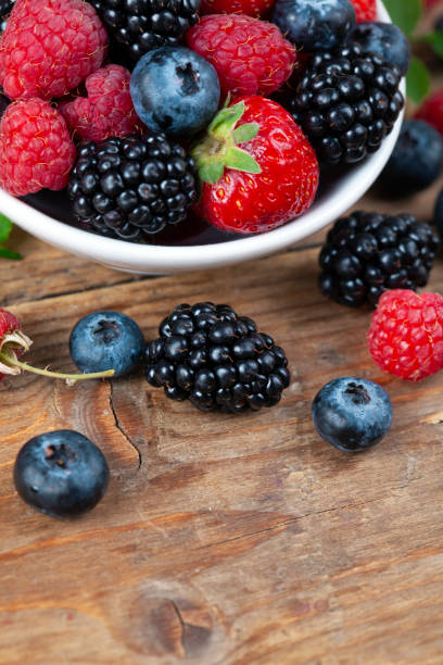 istock Assorted berries in a plate on white rustic wooden table 1402374693