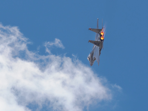 Hillsboro, Oregon, USA - May 21, 2022 : A sharp turn on a fly-by of an Oregon Air National Guard USAF F-15C Eagle. The Air Show in Hillsboro, Oregon is a very popular event each year. The theme for 2022 was “She Flies with her own wings.” All performers, pilots and announcers were women. Hillsboro is a suburb of the city of Portland, Oregon. Photo taken from a public sidewalk outside of the airport property.