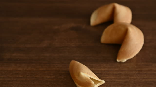 Person taking out blank note with good luck wish from fortune cookie