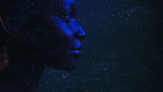 Human universe. Cosmic portrait. Dream consciousness. Neon blue closeup profile silhouette of mysterious woman face on dark night stardust wrinkled texture copy space background.