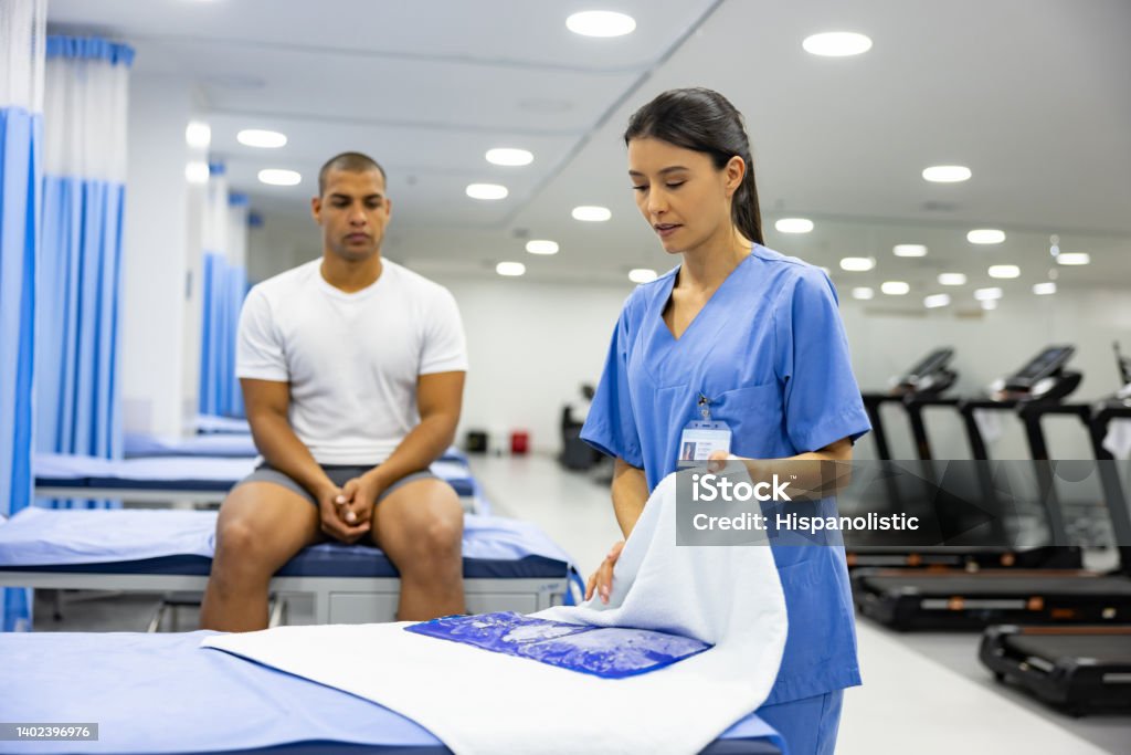 Physiotherapist preparing an ice pack to put on a patient Physiotherapist preparing an ice pack to put on a patient at a rehabilitation center Cryotherapy Stock Photo