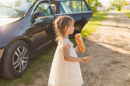 Family car trip at summer. Children eating baguette. Fresh bakery. Go on trip. Journey. Outdoor recreation. Childhood. Leisure activity