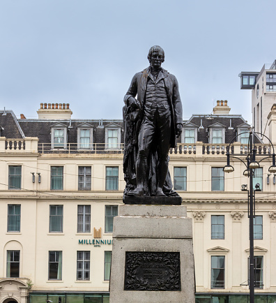 Glasgow, Scotland, United Kingdom - May 3, 2022: View of a statue of famed Scotland national poet Robert Burns in George Square in Glasgow. The bronze statue was created by sculptor George Edwin Ewing, and unveiled in 1877.