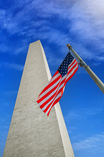 Washington monument with the USA flag on a sunny day. Washington D.C. USA.