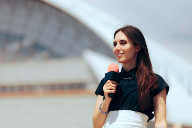 istock Happy Journalist Holding a Microphone Reporting Outdoors 1402409008