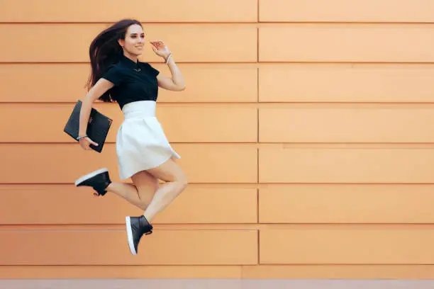 Photo of Happy Cheerful Businesswoman Jumping Holding a Portfolio Case