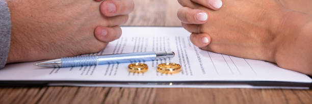 istock Couple's Hand With Divorce Agreement And Wedding Rings 1402409751