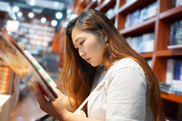 Asian middle-aged man borrowing books at city public library