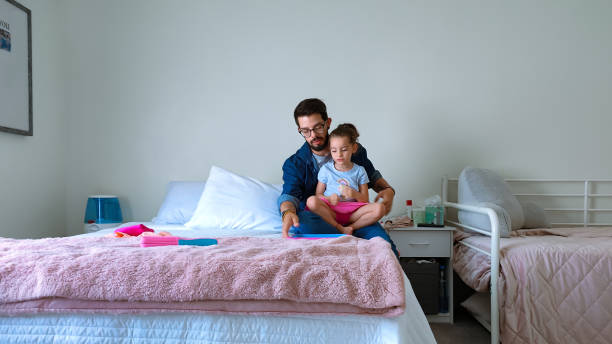 istock Father and daughter using a tablet at home 1402409857