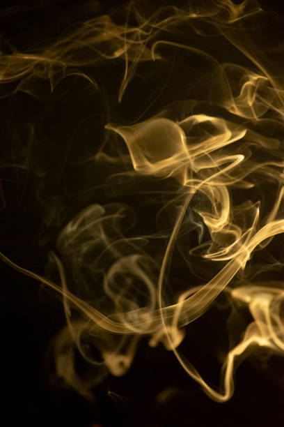 istock A golden yellow swirling smoke pattern, black Background 1402411268