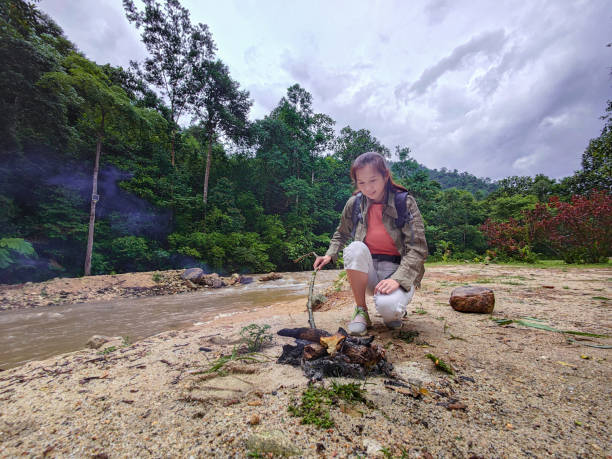 istock Woman lightening campfire while adventure outdoor. 1402414234