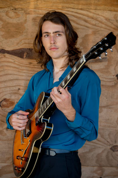istock Young man  plays his guitar whilst waiting for a friend. 1402414421