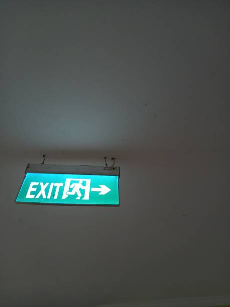 sign 'exit' In the room an 'exit' sign hanging above from a room emergency exit photos stock pictures, royalty-free photos & images