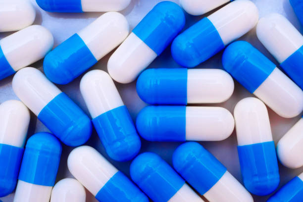 istock Macro of top view on blue and white pills scattered  on white background 1402421080