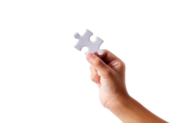 hand holding a blank jigsaw piece on a white background - incomplete puzzle jigsaw puzzle part of imagens e fotografias de stock