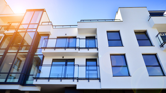 Modern minimalist architecture with lots of square glass windows and balconies.