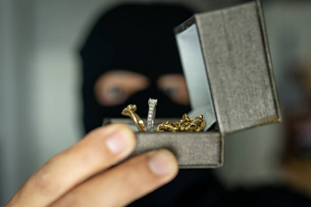 Burglar Standing Behind Curtain At Window Looking At Diamond Ring. Burglar Standing Behind Curtain At Window Looking At Diamond Ring. pickpocketing stock pictures, royalty-free photos & images