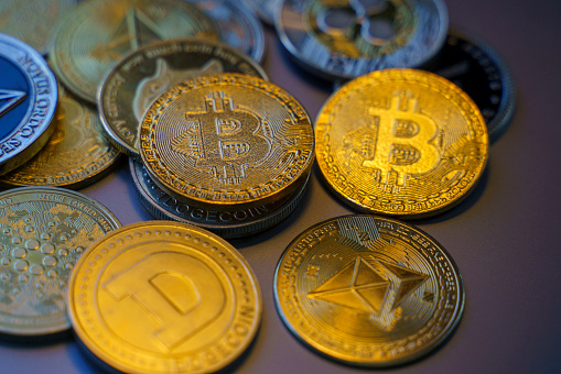 Antalya, Turkey - April 26, 2022: Close up shot of Bitcoin and alt coins cryptocurrency over gray background