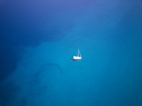 Droneshot of a sailboat on anchor