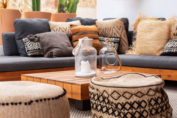 istock 2 glass vases on a low wooden coffee table surrounded by two soft ottomans and a corner sofa with a heap of various cushions. Patio of Mediterranean villa 1402439176