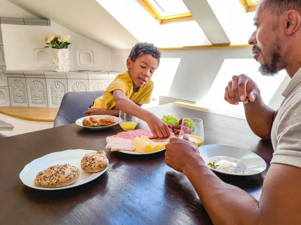 istock Father Eating Breakfast With His Young Son 1402447702