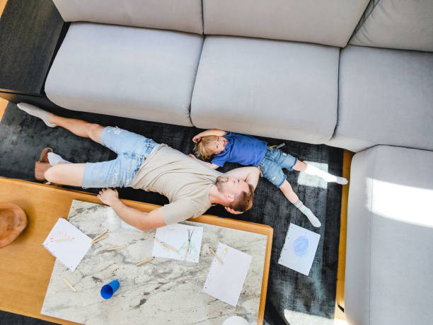 istock Young Child And His Father Lying Down On The Sofa And Talking 1402447778