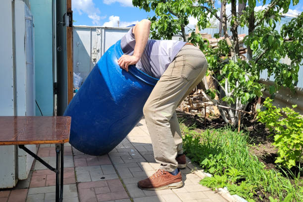 A male worker washes a large barrel inside sticking his head and torso.