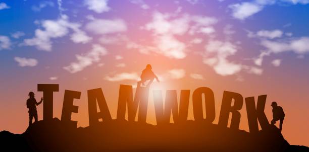 istock Silhouette of  team work making teamwork words in sunset sky background 1402450256