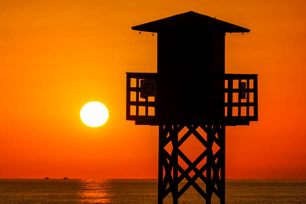 Red sunset on the beach with a lifeguard watchtower