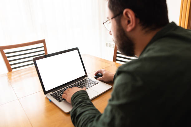 istock Blank laptop screen of a man working at home 1402452977