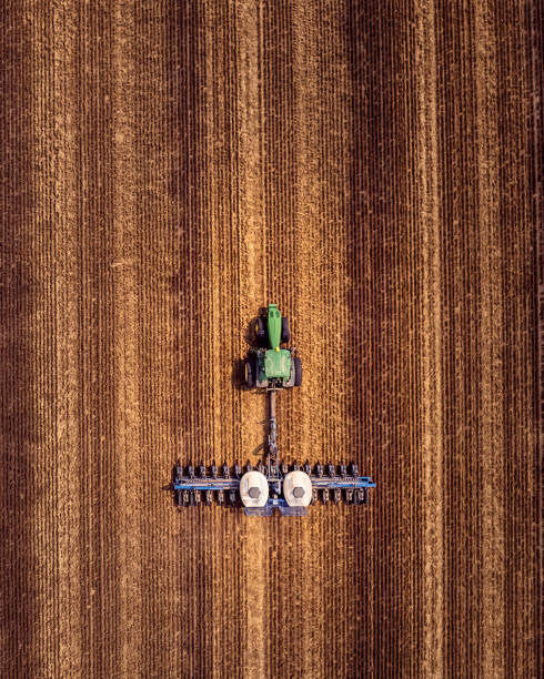 Tractor and Planter Planting in a Field stock photo