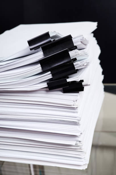 istock A stack of office papers, some of which are fastened with black binders 1402454594