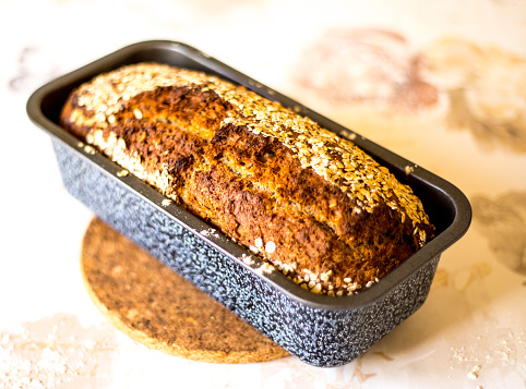 Rye bread with sesame,flax, sunflower and poppy seeds, loaf with slices on wooden cutting board isolated on white with clipping path