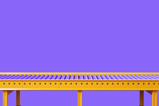 Transportador amarillo vacío sobre fondo violeta, línea de montaje, espacio de copia photo