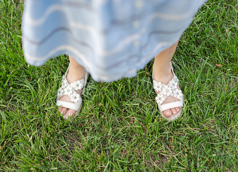 Little Girl Standing on Grass with Sandals