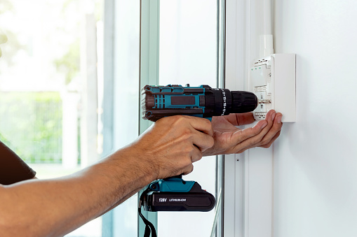 Install the power sockets and switches in the outlet box on the wall with a cordless hand drill.