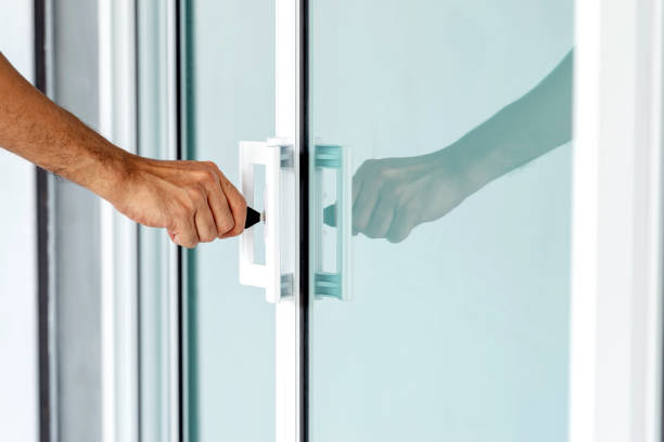 istock Man's hand opening a glass door with a key. 1402458654