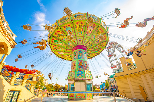 Vienna, Austria - 29 May, 2022: Prater amusement park and swing carousel over blue sky