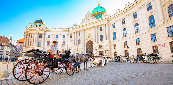 Vienna, Austria - 5 May, 2022: Hofburg Palace and horse carriage in Wien city