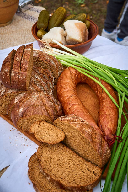 Slices of fresh rye bread, sausage ring and green onions on the table