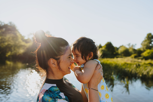 Photo of mother and her baby girl spending summer days by the river.