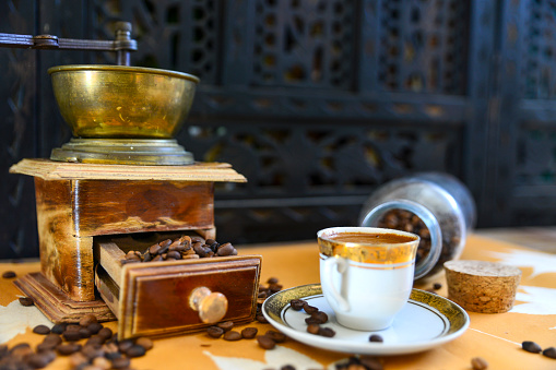 Turkish coffee and old manual coffee grinder with roasted coffee beans