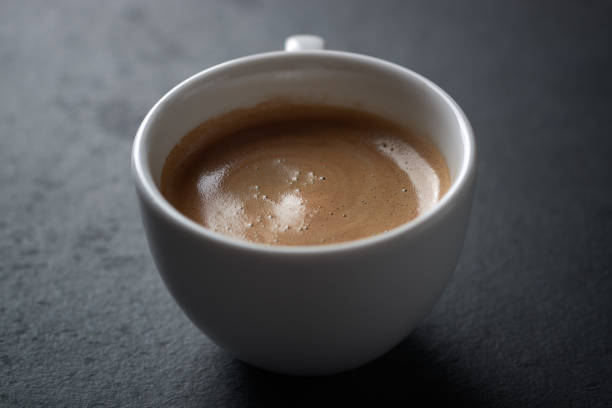 Cup of coffee on dark stone background. Close up. Copy space.