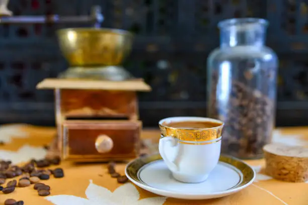 Photo of Turkish coffee and old manual coffee grinder with roasted coffee beans