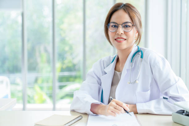 sorridente médica asiática no consultório , retrato de bela médica madura está empenhado em tratar pacientes. healtcare e conceito de assistência - head ware - fotografias e filmes do acervo