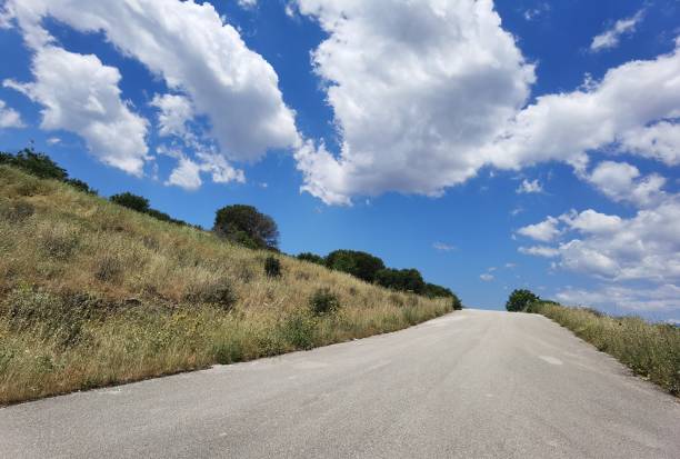road street clouds uphil path vivid spring color on the sky