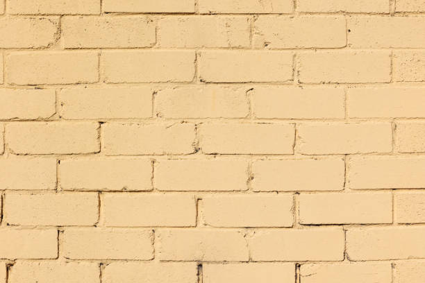 Close-up on an old yellow brick wall.