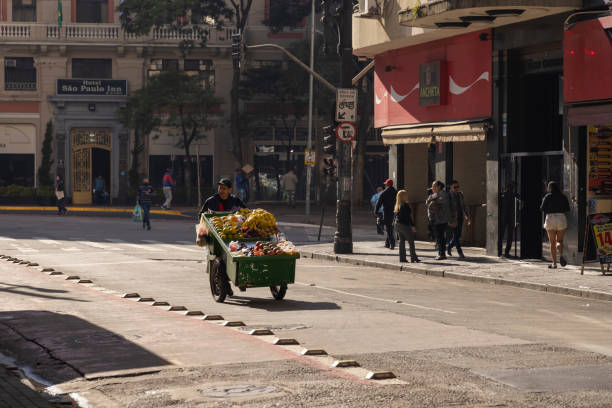 Man pushes his cart with fruit in the city center early in the morning stock photo