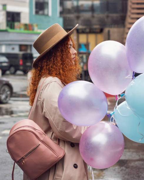 Girl walks streets with bunch balloons