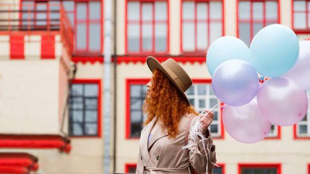 istock Girl walks streets with bunch balloons 1402475222